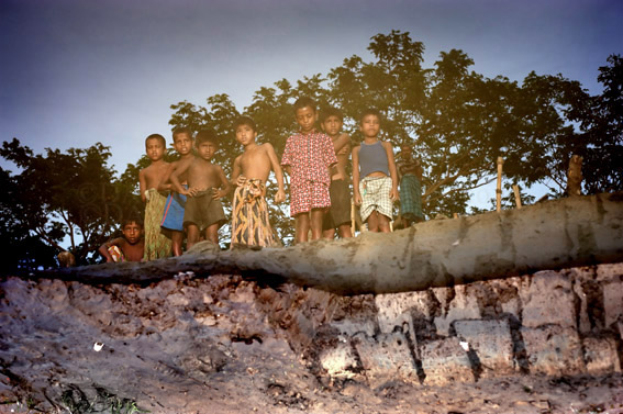 Climate change, Bangladesh, 9.2009. Trying to rebuild village defences against the rivers, Alimoddi, Bhola island...children reflected in the pools created when locals dig mud to shore up their defences against the rising water levels. This image has been turned upside down.