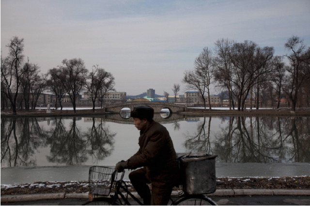 Feb. 12, 2012. A North Korean man rides a bike along the banks of the Pothong River in Pyongyang. © David Guttenfelder 