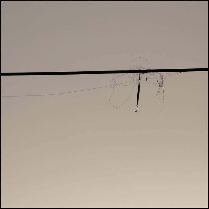 Fishing lure on electrical wire high above the river, Bunarkaig © John MacPherson