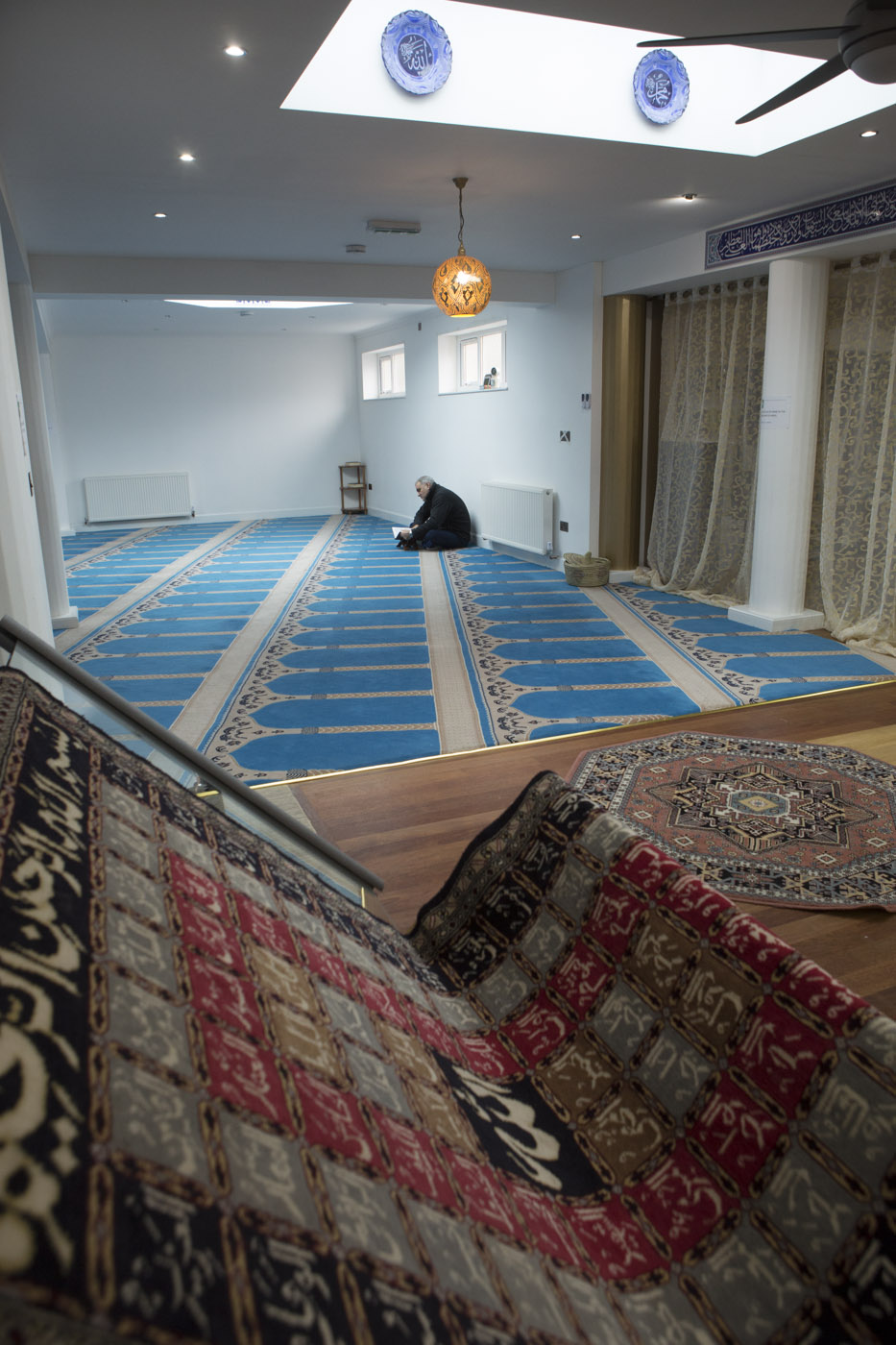 An early arrival for Friday prayers contemplates the Quran, Inverness Masjid, Inverness, Scotland, February 2015 Image ©John MacPherson